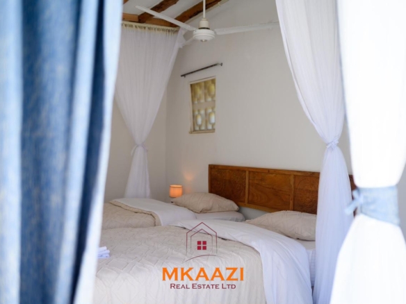 Fully furnished 4-bedroom riverside holiday house accommodating up to 10 guests with hippo views, spacious compound, and fully equipped kitchen.