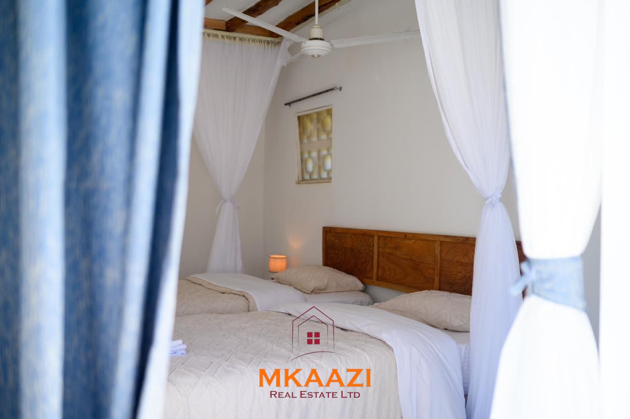 Fully furnished 4-bedroom riverside holiday house accommodating up to 10 guests with hippo views, spacious compound, and fully equipped kitchen.