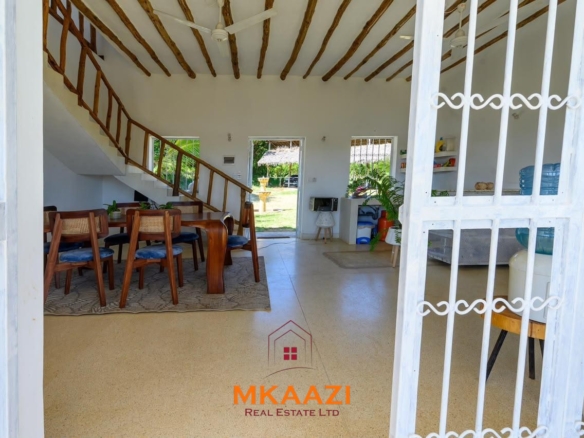 Fully furnished 4-bedroom riverside holiday house accommodating up to 10 guests with hippo views, spacious compound, and fully equipped kitchen.