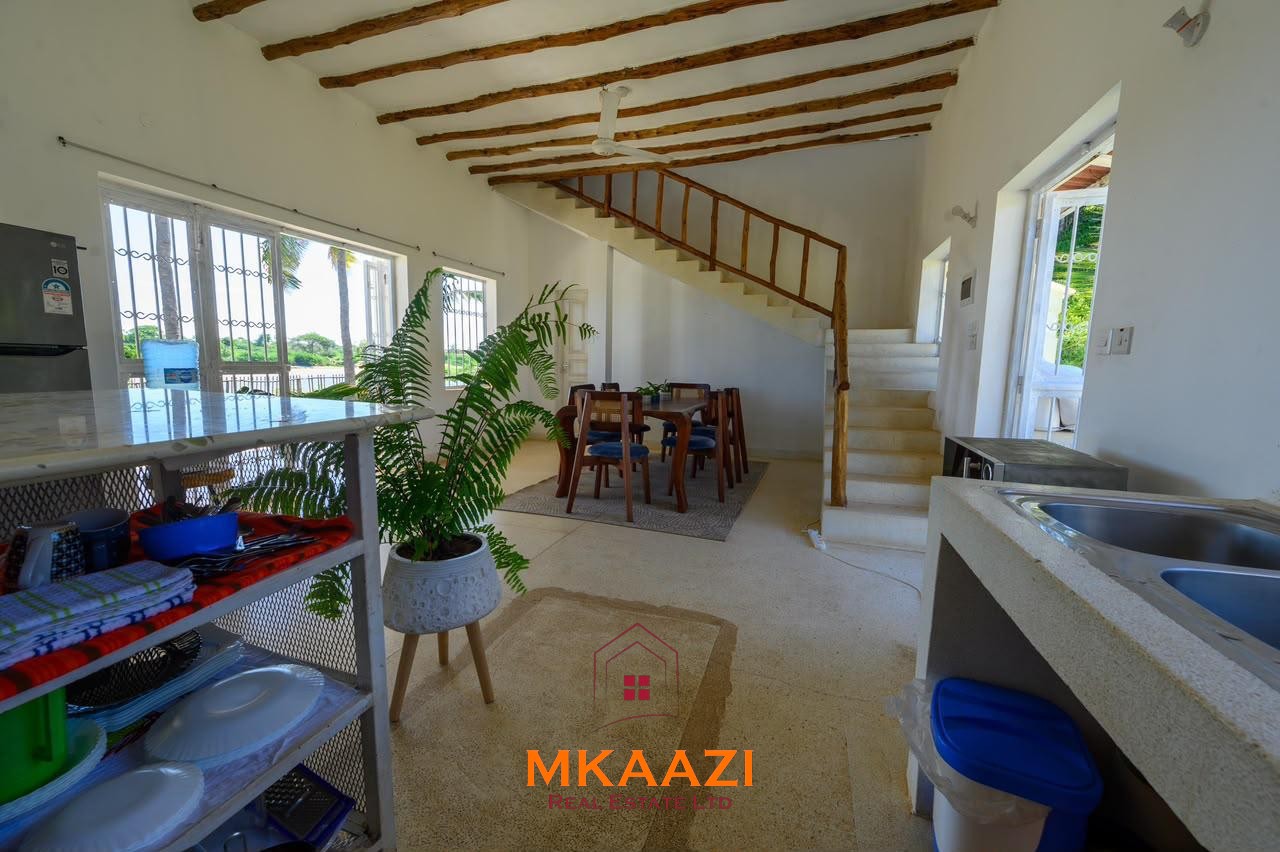 Fully furnished 4-bedroom riverside holiday house accommodating up to 10 guests with hippo views, spacious compound, and fully equipped kitchen.