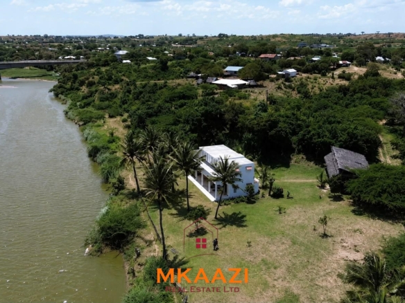 Fully furnished 4-bedroom riverside holiday house accommodating up to 10 guests with hippo views, spacious compound, and fully equipped kitchen.