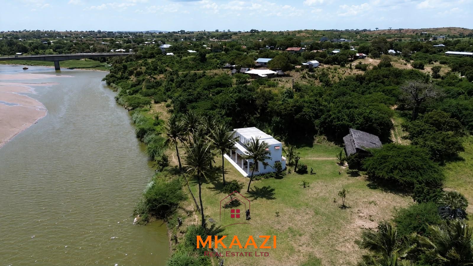 Fully furnished 4-bedroom riverside holiday house accommodating up to 10 guests with hippo views, spacious compound, and fully equipped kitchen.