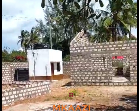 Half-acre property for sale off Kanani Road in Watamu with a 2-bedroom house, 1-bedroom SQ and three unfinished rental units near Watamu Mall.