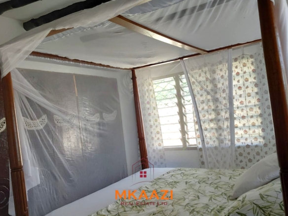 Half-acre property for sale off Kanani Road in Watamu with a 2-bedroom house, 1-bedroom SQ and three unfinished rental units near Watamu Mall.