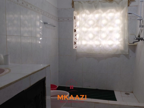 Half-acre property for sale off Kanani Road in Watamu with a 2-bedroom house, 1-bedroom SQ and three unfinished rental units near Watamu Mall.