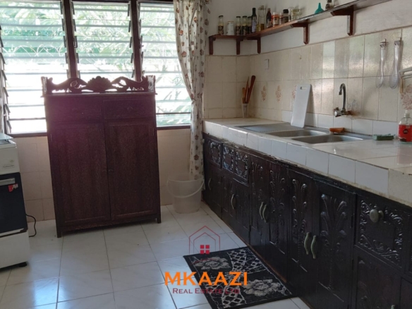 Half-acre property for sale off Kanani Road in Watamu with a 2-bedroom house, 1-bedroom SQ and three unfinished rental units near Watamu Mall.