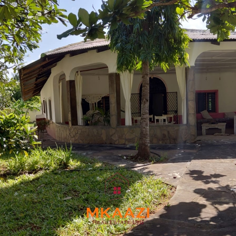 Half-acre property for sale off Kanani Road in Watamu with a 2-bedroom house, 1-bedroom SQ and three unfinished rental units near Watamu Mall.