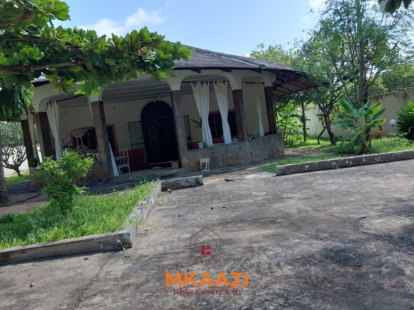 Half-acre property for sale off Kanani Road in Watamu with a 2-bedroom house, 1-bedroom SQ and three unfinished rental units near Watamu Mall.