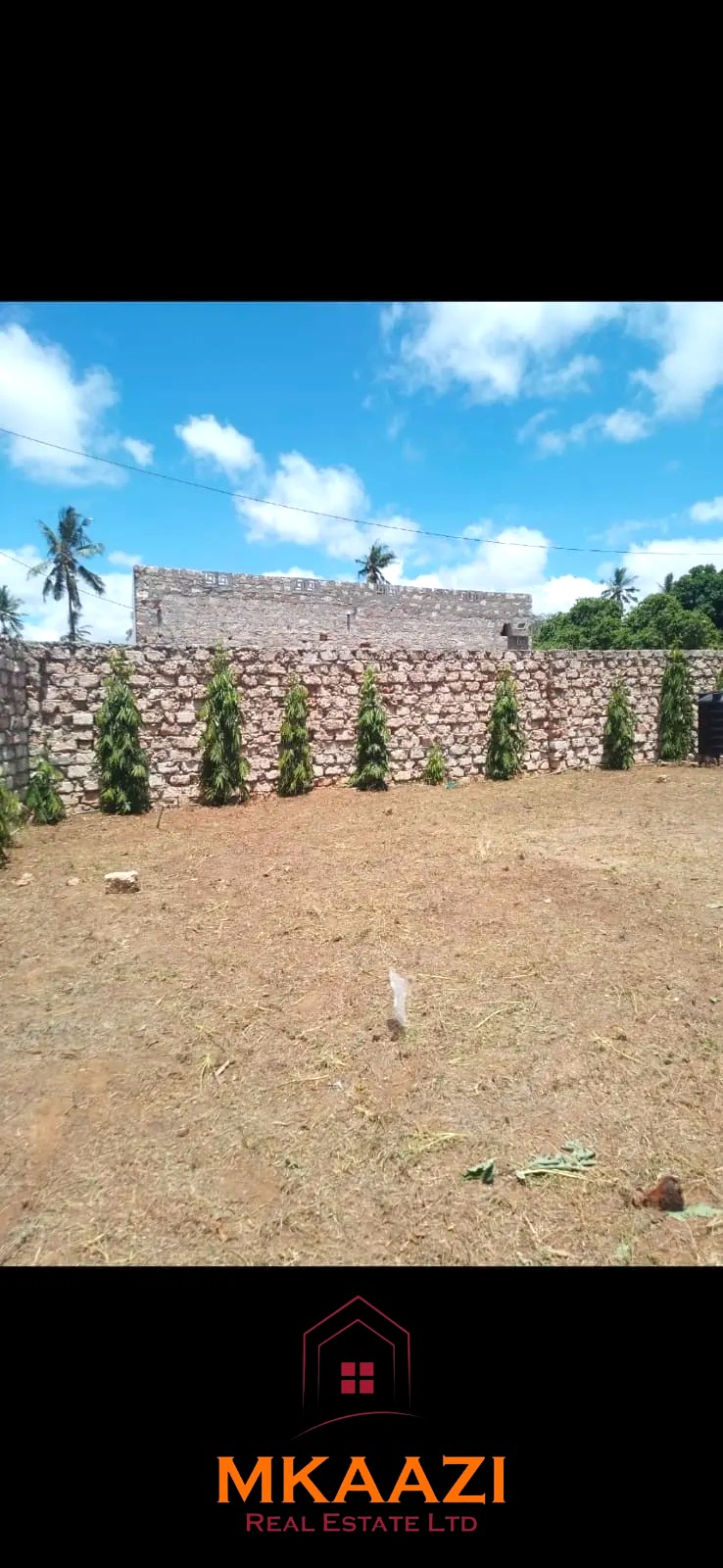 Secure flat plot for sale in Mavueni, Kilifi, featuring a coral stone perimeter wall, heavy gate and convenient access to the Malindi Highway and Kilifi Town.