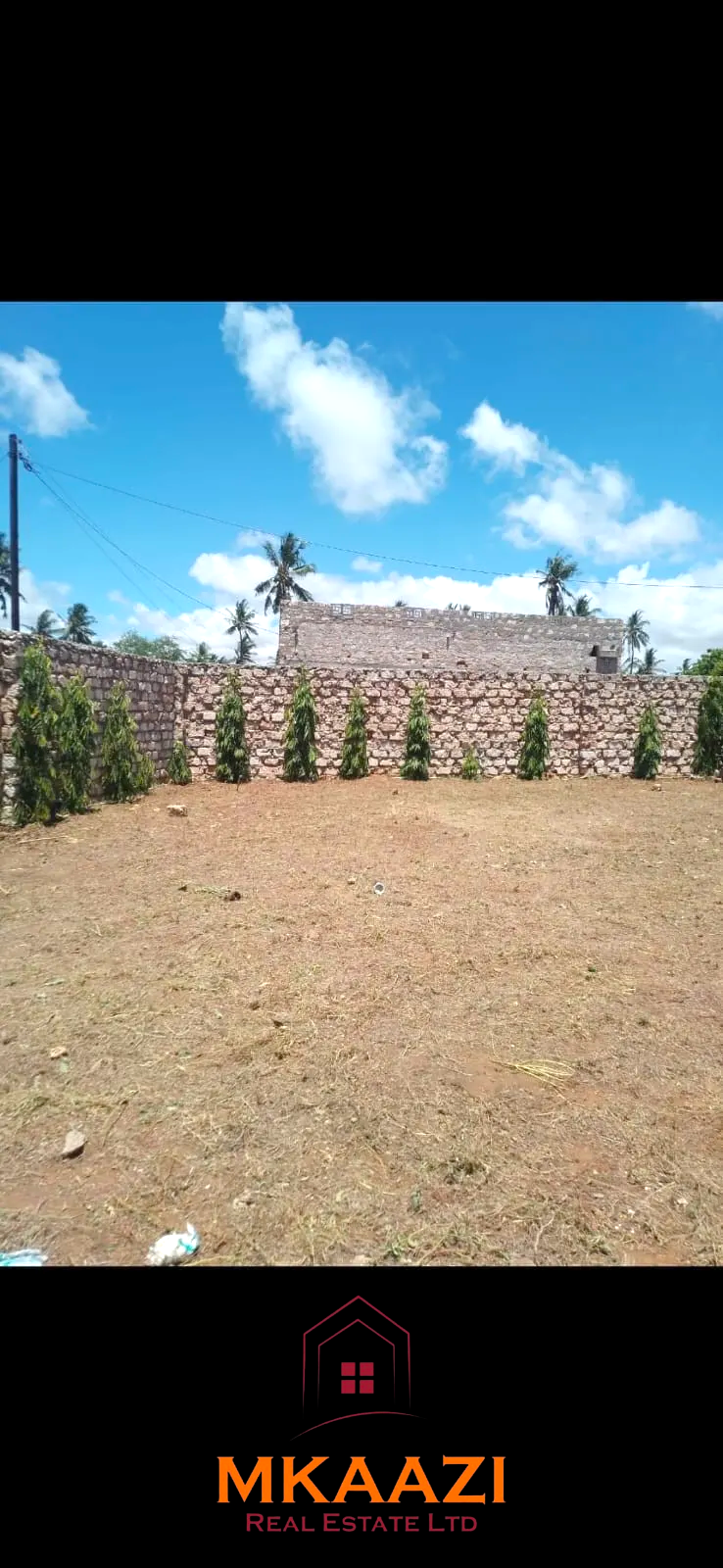 Secure flat plot for sale in Mavueni, Kilifi, featuring a coral stone perimeter wall, heavy gate and convenient access to the Malindi Highway and Kilifi Town.