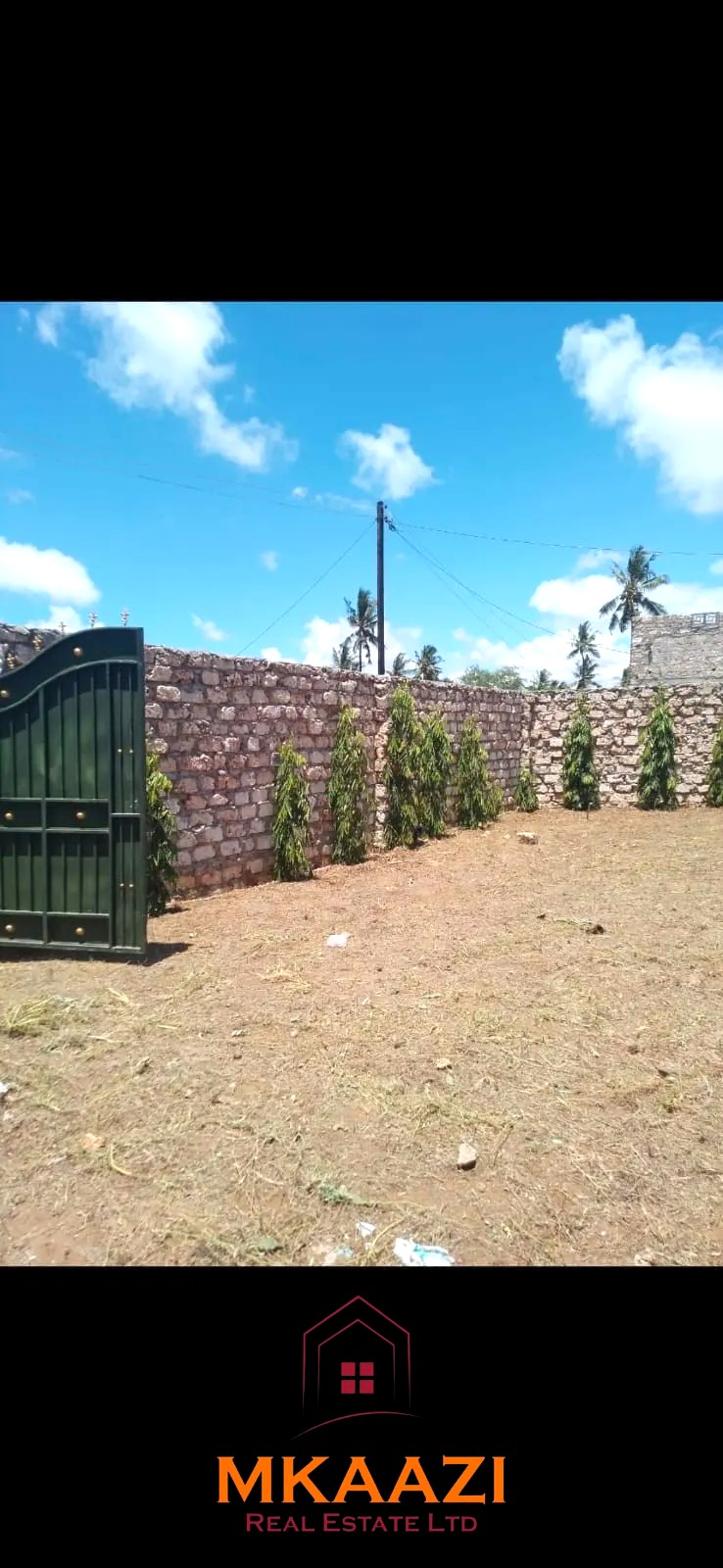 Secure flat plot for sale in Mavueni, Kilifi, featuring a coral stone perimeter wall, heavy gate and convenient access to the Malindi Highway and Kilifi Town.
