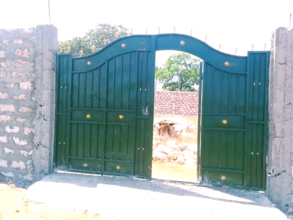 Secure flat plot for sale in Mavueni, Kilifi, featuring a coral stone perimeter wall, heavy gate and convenient access to the Malindi Highway and Kilifi Town.