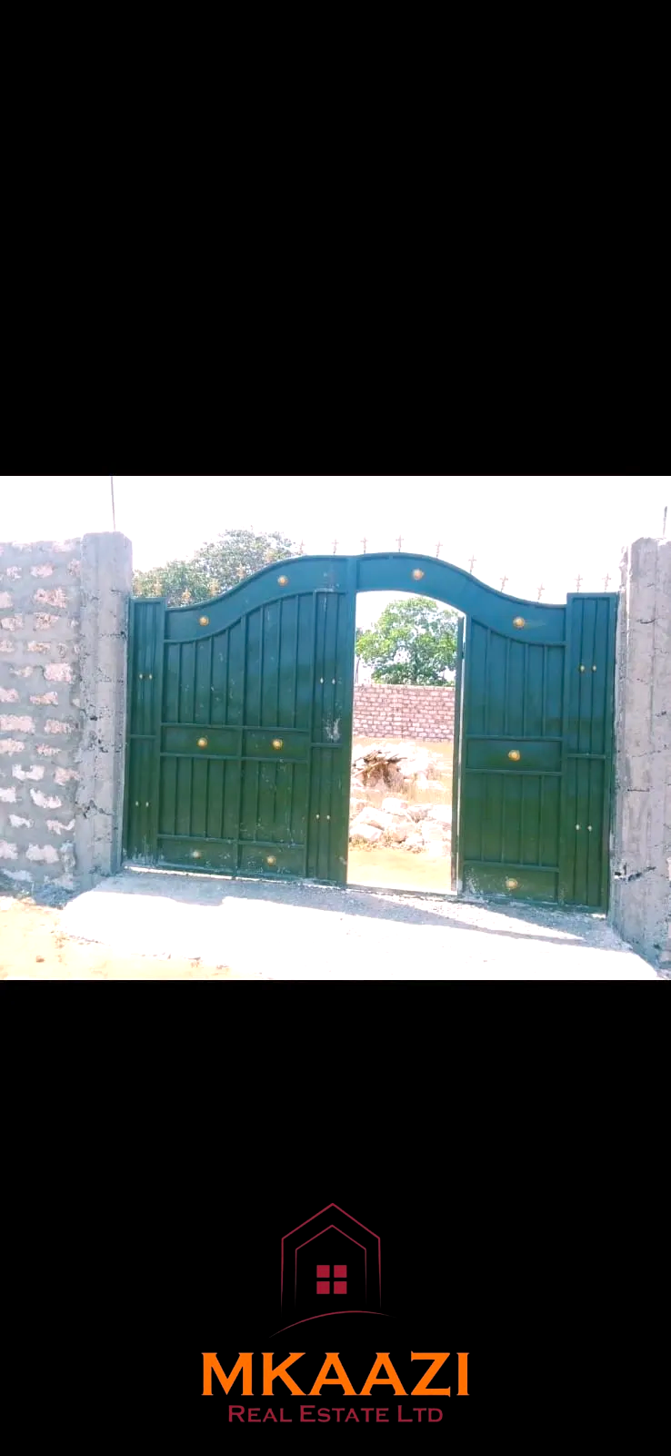 Secure flat plot for sale in Mavueni, Kilifi, featuring a coral stone perimeter wall, heavy gate and convenient access to the Malindi Highway and Kilifi Town.